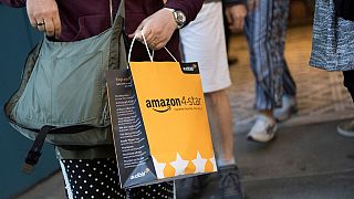 A customer carries a bag as they leave a new Amazon store where everything for sale is rated 4 stars and above.