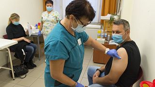 Egy magyar férfi megkapja a Comirnaty-vakcina harmadik, emlékeztető adagját a győri Petz Aladár Megyei Oktató Kórház oltópontján 2021. október 7-én
