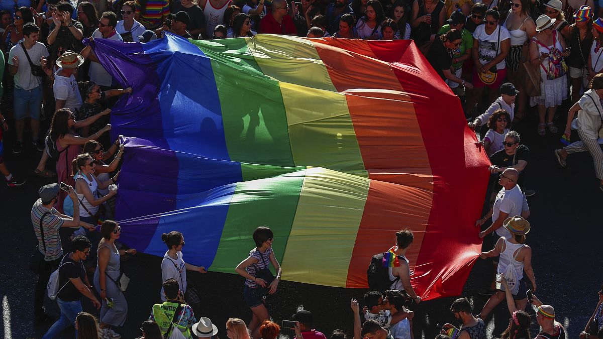 Participants of the annual LGBT+ pride parade carry the rainbow flag in Madrid.