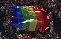 Participants of the annual LGBT+ pride parade carry the rainbow flag in Madrid.