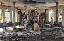 People view the damage inside of a mosque following a bombing in Kunduz, province northern Afghanistan