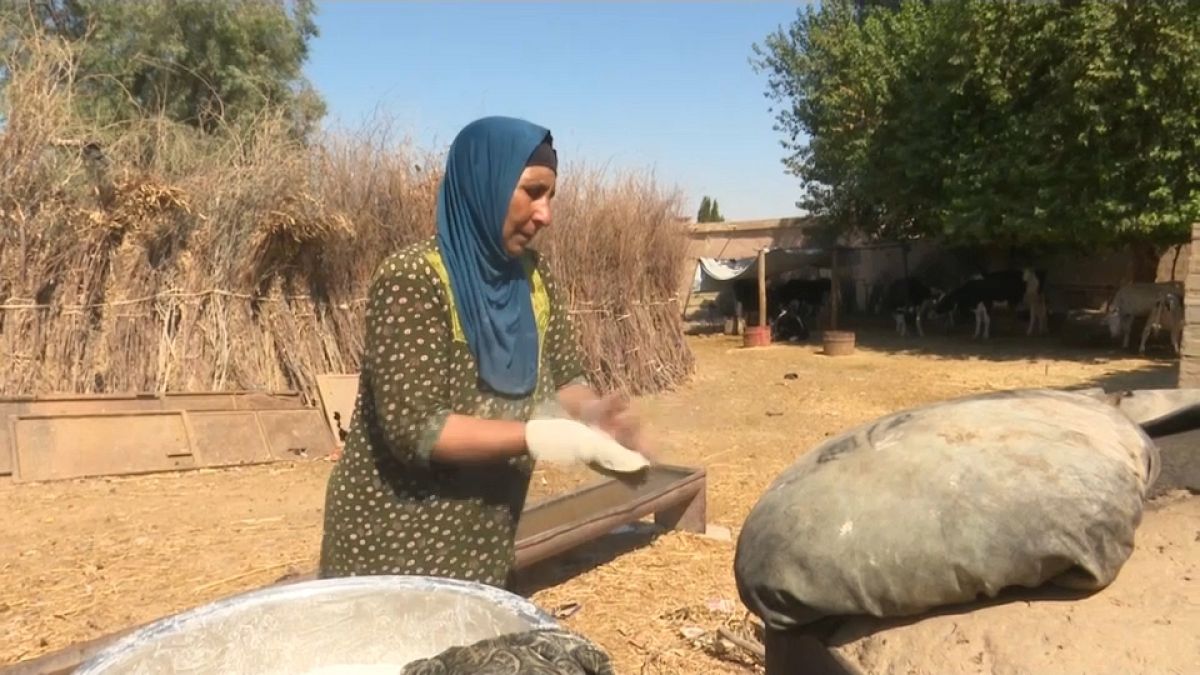 Qahwa, a Syrian mother of eight, is baking the traditional tannour bread. 