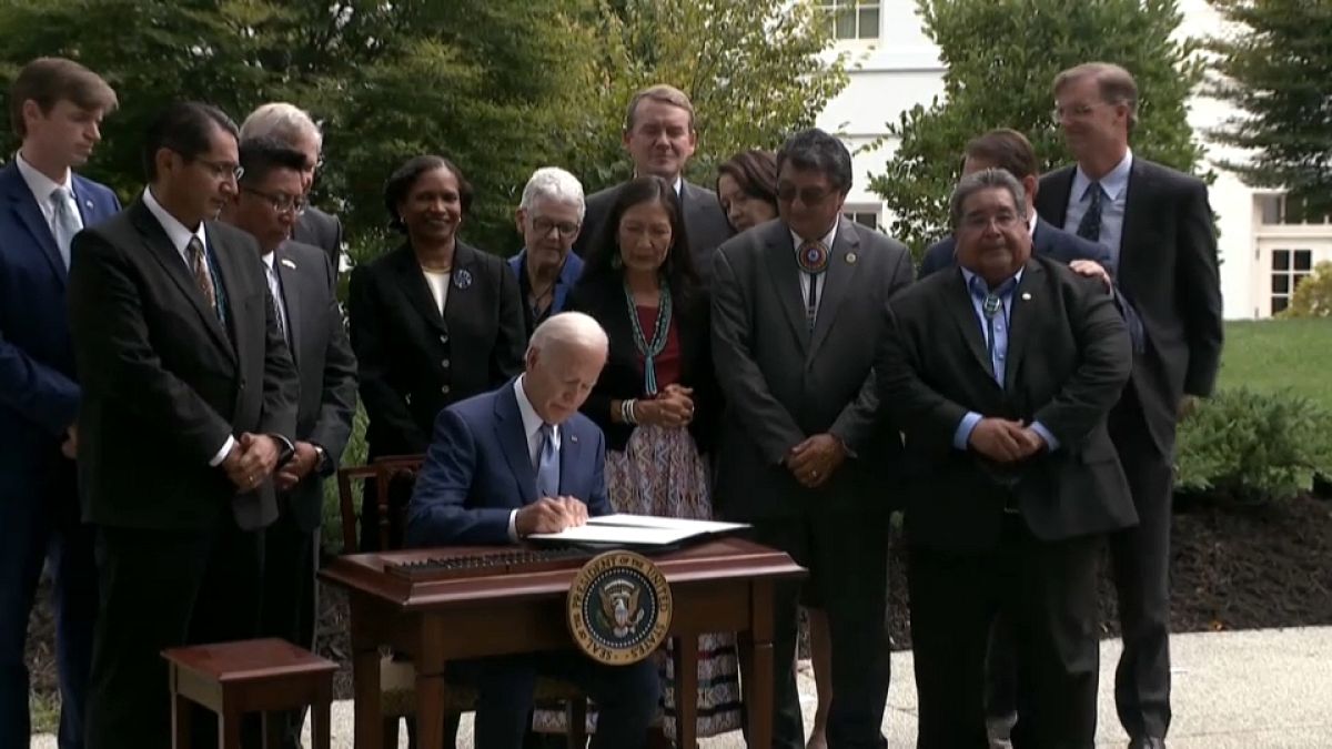 El presidente Joe Biden, este viernes, firmando las órdenes