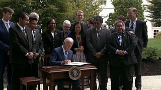 El presidente Joe Biden, este viernes, firmando las órdenes