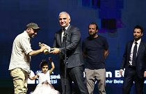 En İyi Film ödülünü kazanan "Okul Tıraşı" filminin yönetmeni Ferit Karahan'a (solda), ödülünü Kültür ve Turizm Bakanı Mehmet Nuri Ersoy verdi