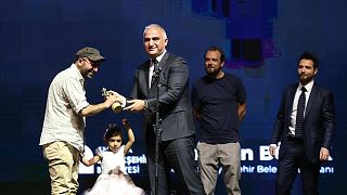 En İyi Film ödülünü kazanan "Okul Tıraşı" filminin yönetmeni Ferit Karahan'a (solda), ödülünü Kültür ve Turizm Bakanı Mehmet Nuri Ersoy verdi