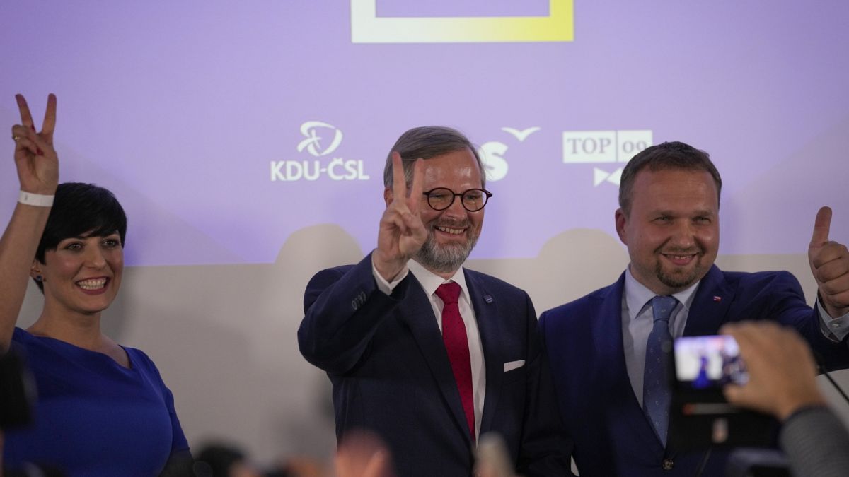 Petri Fiala, a hárompárti Együtt koalíció vezetője (középen) ünnepel az eredményvárón Prágában