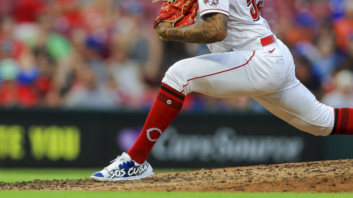 Jugador de béisbol con el mensaje SOS Cuba en su calzado