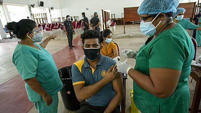 A Sri Lankan university student receives his coronavirus vaccine at the Sri Jayawardenapura university in Colombo, Sri Lanka, Monday, Oct. 11, 2021.