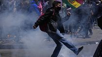 Un manifestante da una patada a un proyectil de gases lacrimógenos en La Paz, Bolivia