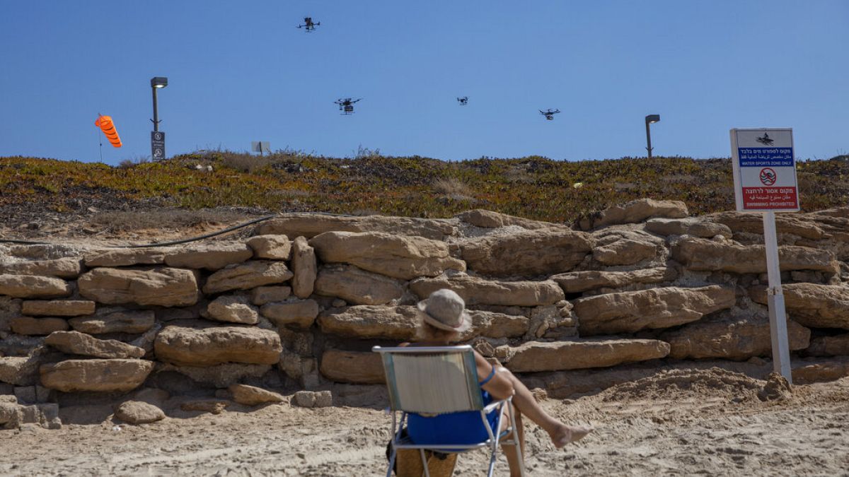 Áruszállító drónokat néz egy nyaraló Tel Aviv tengerpartján