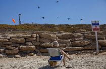 Áruszállító drónokat néz egy nyaraló Tel Aviv tengerpartján