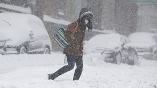 A woman crosses the street during a 2021 blizzard in New York.