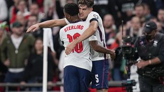 England's John Stones, right, and teammate Raheem Sterling during the World Cup 2022 group I qualifying match against Hungary, Wembley, London, Oct. 12, 2021.