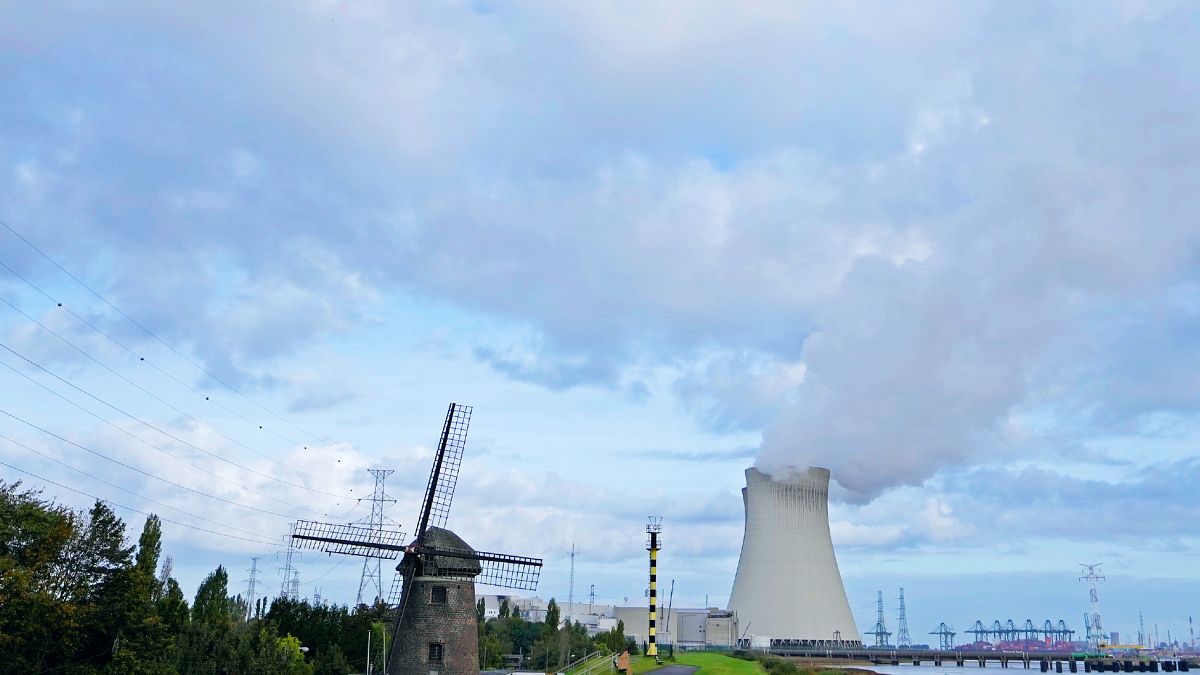 Gőz gomolyog egy atomerőműből egy régi szélmalom mellett a belgiumi Doelben
