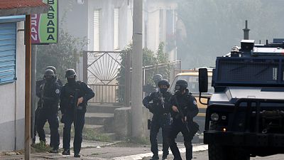 ضباط شرطة كوسوفو يحرسون شارعًا في الجزء الشمالي الذي يسيطر عليه الصرب من بلدة ميتروفيتشا المنقسمة عرقياً في كوسوفو.