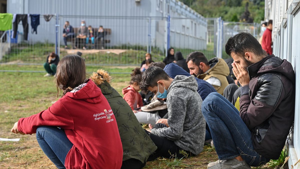 Almanya'nın Brandenburg eyaletindeki sığınmacı kabul merkezinin önünde oturan göçmenler
