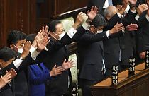 Japanese Prime Minister Fumio Kishida, center, and other lawmakers give three cheers after dissolving the lower house, the more powerful of the two parliamentary chambers.