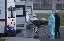 موظفون في قطاع الصحة في روسيا ينزلون مريضاً يشتبه بإصابته بـ"كوفيد-19" من سيارة الإسعاف لإدخاله إلى مستشفى كوموناركا قرب العاصمة موسكو