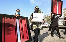 نساء كويتيات يحملن لافتة خلال مسيرة للتنديد بالعنف ضد المرأة، خارج مجلس الأمة، في العاصمة الكويتية، 22 أبريل 2021