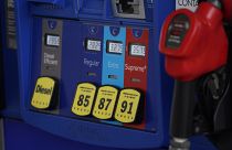 In this May 9, 2021, file photo prices are illuminated above the levers for the different grades of gasoline available at a pump at an Exxon station.