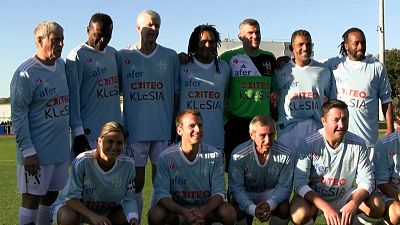 Emmanuel Macron poses for a team photo on the pitch before the Variété Club de France gala match
