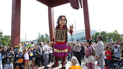 Giant puppet Amal, created by Handspring Puppet Company symbolizing a young refugee girl, walks in support of refugees