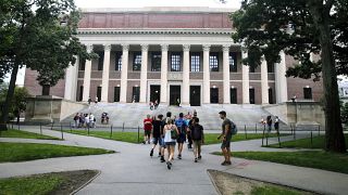طلاب يمشون بالقرب من مكتبة ودينير في جامعة هارفارد في كامبريدج، ماساتشوستس.
