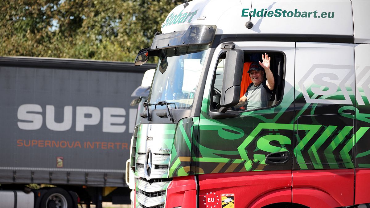 A driver gestures as he departs from Ashford International truck stop, in Ashford, south-east England on October 5, 2021.