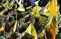Hezbollah fighters raise their group flags in the southern village of Adloun, Lebanon in May