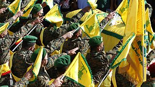 Hezbollah fighters raise their group flags in the southern village of Adloun, Lebanon in May