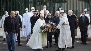 أئمة من المسجد الكبير في باريس يحملون جزية من الزهور ، أمام المدرسة التي كان يعمل فيها المعلم صاموئيل باتي ، في كونفلانس سانت هونورين ، الجمعة 15 أكتوبر 2021.