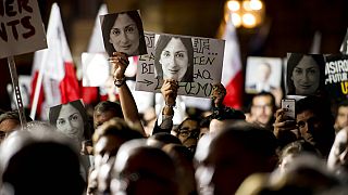 Protesters hold photos of murdered journalist Daphne Caruana Galizia at a demonstration in Valletta on November 19, 2019