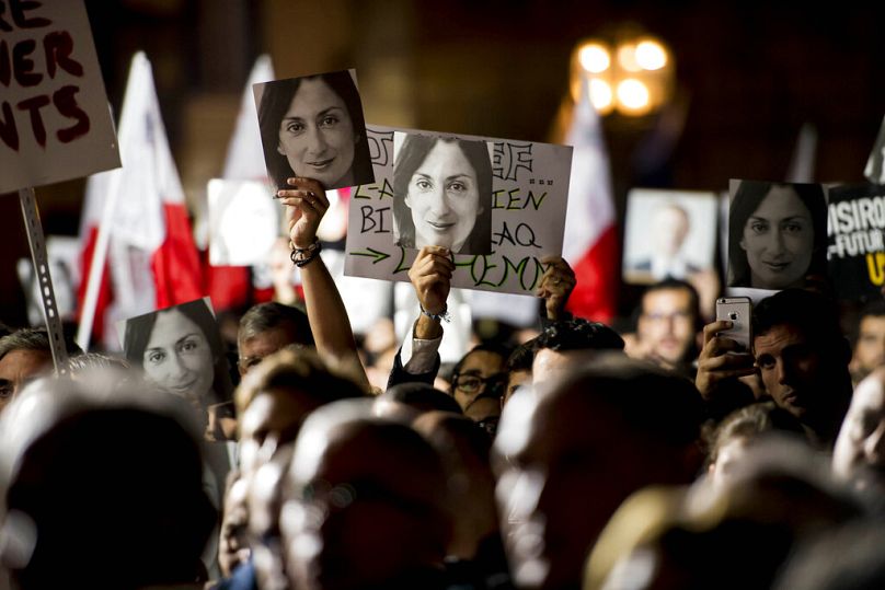 Protesters hold photos during a protest outside the office of the Prime Minster of Malta by civil groups Occupy Justice and Republica in La Valletta, November 2019