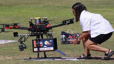 This picture taken on October 11, 2021 in the Israeli coastal city of Herzliya shows a woman loading goods into a drone as it carries deliveries during Drone Intitiative test.