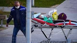A medical worker carries a patient suspected of having coronavirus on a stretcher at a hospital in Kommunarka, outside Moscow, Russia, Monday, Oct. 11, 2021.