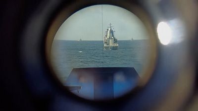 View of warships through telescope during drills.