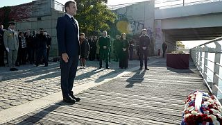 French President Emmanuel Macron stands at attention after laying a wreath near the Pont de de Bezons (Bezons bridge) Saturday, Oct. 16, 2021 in Colombes near Paris.