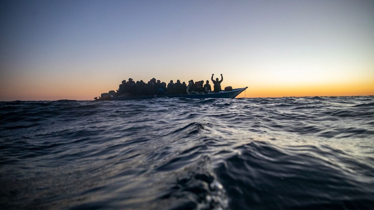 مهاجرون ولاجئون على متن قارب خشبي مكتظ، في البحر الأبيض المتوسط.