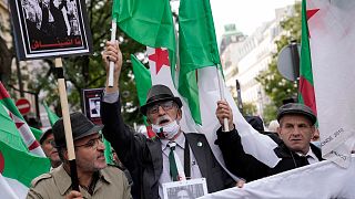 Demonstrators holding Algerian flags chant slogans in Paris, Sunday, Oct. 17, 2021.