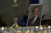 Candles are lit next to a portrait of British Lawmaker David Amess during a vigil for him at St Michaels Church, in Leigh-on-Sea, England Sunday, Oct. 17, 2021.