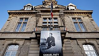 A photo of French teacher Samuel Paty is displayed on the city hall in Conflans-Sainte-Honorine.