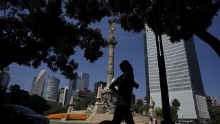 Un hombre trota frente al monumento del Ángel de la Independencia, 18/10/2021, Ciudad de México, México