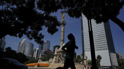 Un hombre trota frente al monumento del Ángel de la Independencia, 18/10/2021, Ciudad de México, México