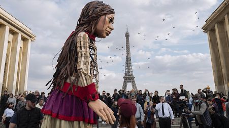 People attend the "Little Amal" show at Trocadero in front of the Eiffel Tower Paris, France, Friday, October 15, 2021.