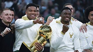 Les frères Antetokounmpo posent avec le trophée et leurs bagues de champions NBA