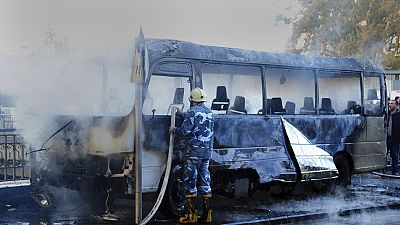 Un pompier syrien sur le site des explosions, éteignant le feu du bus militaire, Damas, Syrie, 20 octobre 2021 
