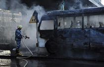 A Syrian firefighter extinguishes a burned bus at the site of a deadly explosion, in Damascus, Syria, 20 Oct. 2021.