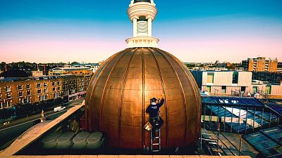 A person works at the newly restored dome of the KOKO Theater, in Camden, London