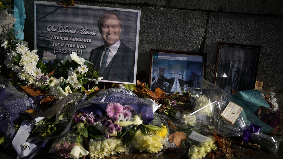 Floral tributes and pictures of British MP David Amess outside the Houses of Parliament in London.